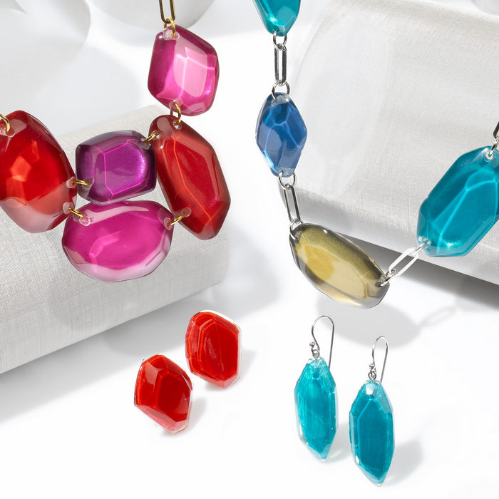 Pedra collection — Faceted, gem-cut nuggets gathered into jewel-bright strands on gold or silver paperclip chain.