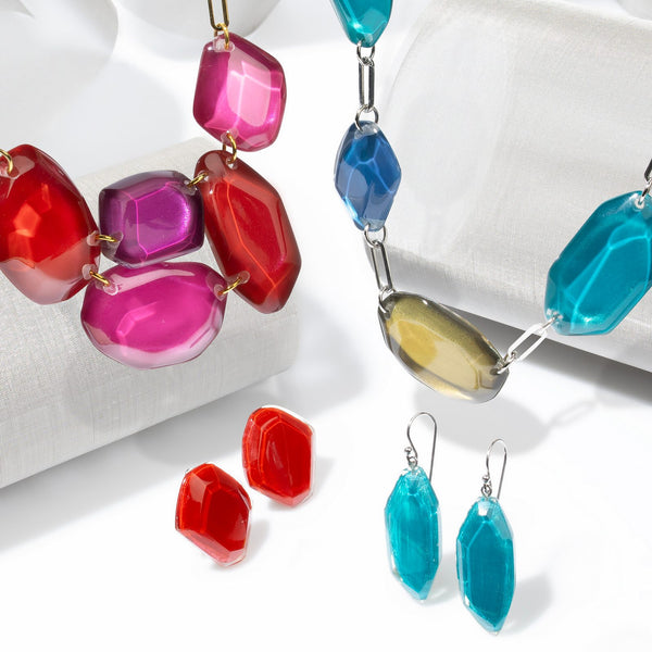 Pedra collection — Faceted, gem-cut nuggets gathered into jewel-bright strands on gold or silver paperclip chain.